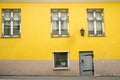 Yellow dirty wall of a dilapidated house on a cobbled street of the old city of Riga. Royalty Free Stock Photo