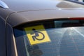 Yellow disabled driver sign at the back of a car Royalty Free Stock Photo