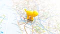 A yellow dog plastic figure standing on Rome on a map of Italy