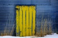 Yellow Door on Metal Grain Silow in Winter with Weeds Royalty Free Stock Photo