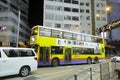 Yellow double decker bus at night