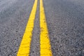 Yellow double dividing line over black highway asphalt Royalty Free Stock Photo