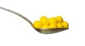 Yellow dragee with vitamins in spoon isolated Royalty Free Stock Photo