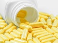 Yellow Drug Capsules Spilled from Container Royalty Free Stock Photo