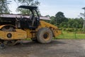 Yellow drum roller machine vehicle parking in the middle of city park