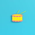 Yellow drum with drum sticks on bright blue background in pastel colors