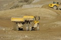 Yellow dump truck working in gravel pit Royalty Free Stock Photo