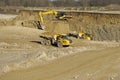 A yellow dump trucks and excavator are working in gravel pit Royalty Free Stock Photo