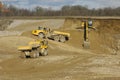 Yellow dump trucks and excavator are working Royalty Free Stock Photo
