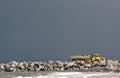 Yellow dumper truck building coastal defence works