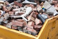 Yellow dumpster skip full of masonry waste