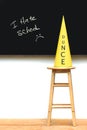 Yellow dunce hat on stool