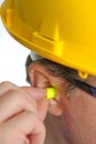 Yellow earplug into the ear Royalty Free Stock Photo