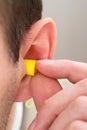 Yellow Earplug Into The Ear Royalty Free Stock Photo