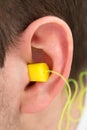 Yellow Earplug Into The Ear Royalty Free Stock Photo