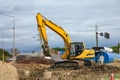 Yellow earthmover backhoe on soil at construction site Royalty Free Stock Photo