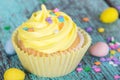 Yellow Easter cupcake with candy and sprinkles Royalty Free Stock Photo