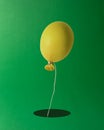 Yellow Easter egg shaped balloon with a rabbit hole on green background. Minimal creative concept Royalty Free Stock Photo