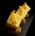 Yellow easter orange mousse textured desserts on pistachio sponge cake slices with mimosa flowers