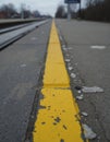 Yellow edge line on a platform with a guard rail in the background Royalty Free Stock Photo