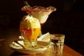 Yellow egg liqueur with whipped cream and a glass of water, black background