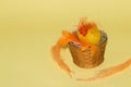 yellow egg shell with decorative orange straw in a vintage basket, creative vintage wallpaper with copy space Royalty Free Stock Photo