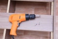 Yellow electric drill and two screws