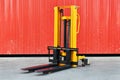 Yellow electric forklift pallet stacker crane in the warehouse front