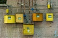 yellow electricity meters on the wall of a residential building