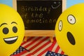 Yellow emoji balloons on the background of the board with the event inscription and American flags. Royalty Free Stock Photo