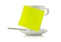 Yellow empty sticky note on white coffee or tea cup over white background Royalty Free Stock Photo