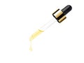 Yellow essential serum oil dripping from gold dropper