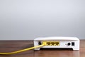 Yellow ethernet cable connected to modem router port on a wooden table