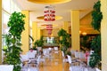 The yellow European interior of cafeteria, bar, public dining room, cafe, food court, buffet, restaurant with elegant white chairs