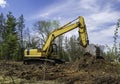 Yellow excavator with bucket resting on a pile of dirt Royalty Free Stock Photo