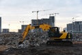 Yellow excavator at a construction site during crushing stones after the demolition of an old building. Salvaging and recycling Royalty Free Stock Photo