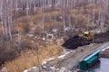 Yellow excavator covers the swamp soil with earth. Nature versus civilization.