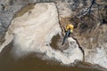 Yellow excavator digger working. Excavator digging sand, ground from water. Industrial aerial drone view