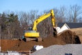 yellow excavator digging earth on nature field