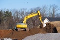 yellow excavator digging earth on nature field