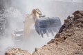 Yellow excavator is filling a dump truck with rocks at coal mines Royalty Free Stock Photo