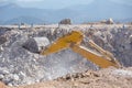 Yellow excavator is filling a dump truck with rocks at coal mines Royalty Free Stock Photo