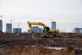 Yellow excavator during groundwork on construction site. Hydraulic backhoe on earthworks. Heavy equipment for demolition,