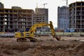 Yellow excavator KOMATSU HB 215 LC Hybrid dig ground at construction site.