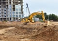 Yellow excavator KOMATSU HB 215 LC Hybrid dig ground at construction site.