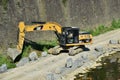 Yellow excavator machine works near Arno river shores, in Florence