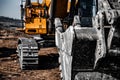 Yellow excavator steel bucket working on construction open mining site