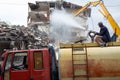 A yellow excavator is working on demolishing an old house in the city of Alanya, Turkey Royalty Free Stock Photo