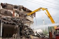 A yellow excavator is working on demolishing an old house in the city of Alanya, Turkey Royalty Free Stock Photo