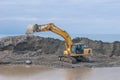 Yellow excavator works at a construction site